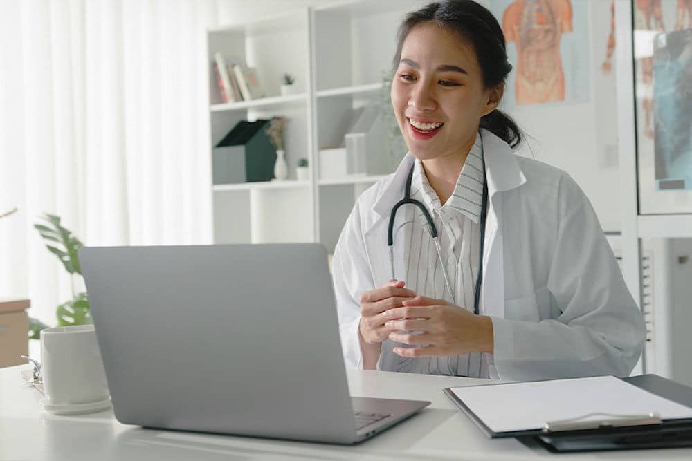 Doctor in medical office explaining to patient over telehealth platform